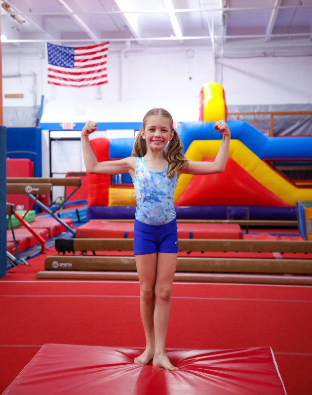 Young girl flexing biceps in gym Young girl flexing biceps in gym